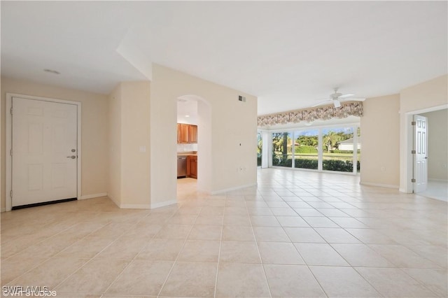 tiled empty room featuring ceiling fan