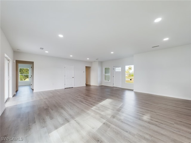 spare room featuring plenty of natural light and light hardwood / wood-style floors