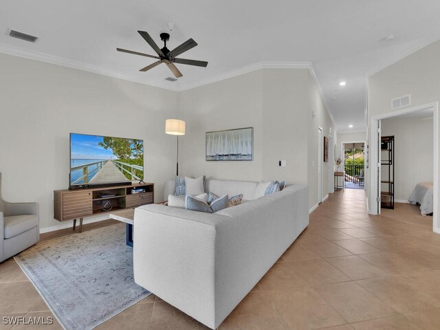 living room featuring light tile patterned flooring, ornamental molding, and ceiling fan