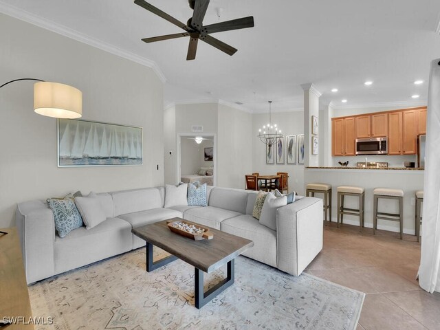 tiled living room featuring crown molding and ceiling fan with notable chandelier