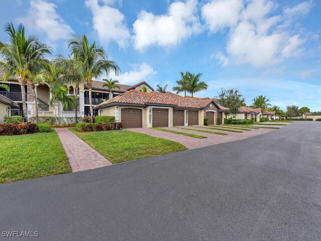 mediterranean / spanish-style home featuring a garage and a front yard