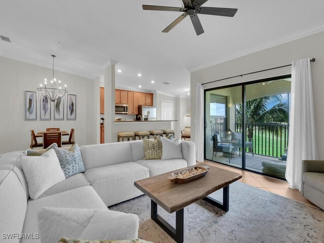 living room featuring ornamental molding, ceiling fan with notable chandelier, and light tile patterned floors