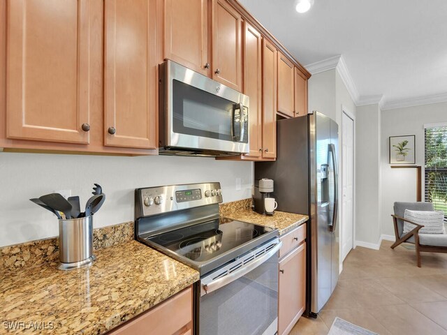 kitchen with light stone counters, ornamental molding, stainless steel appliances, and light tile patterned floors