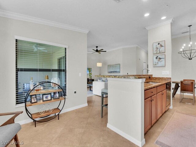 kitchen featuring sink, decorative light fixtures, a kitchen breakfast bar, dishwashing machine, and light stone countertops