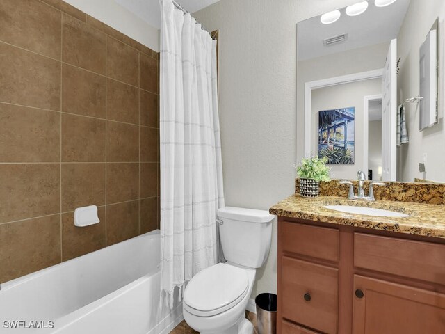 full bathroom featuring vanity, shower / bath combination with curtain, and toilet