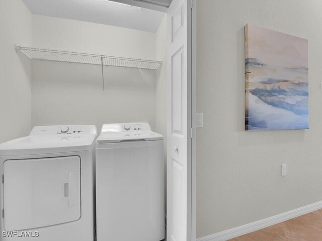 laundry area with light tile patterned floors and independent washer and dryer