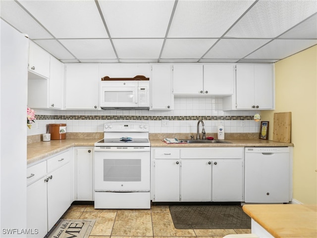 kitchen with white appliances, sink, decorative backsplash, light tile patterned floors, and white cabinetry