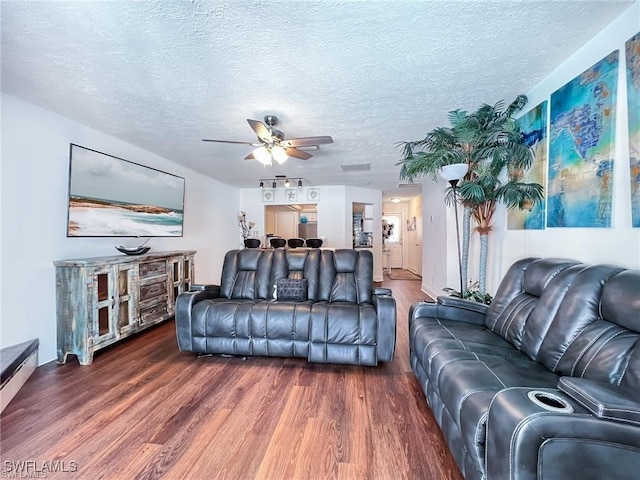 living room featuring a textured ceiling, dark hardwood / wood-style floors, and ceiling fan