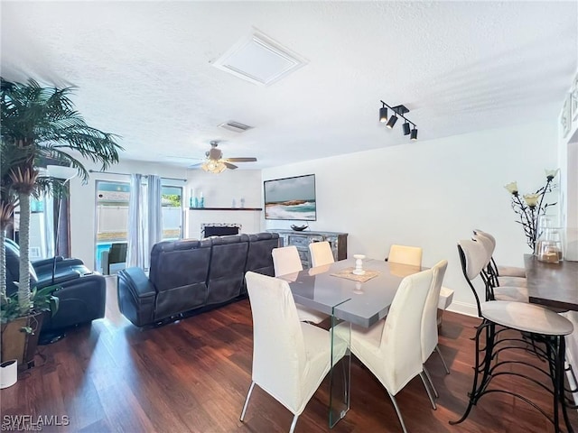 dining room featuring ceiling fan, dark hardwood / wood-style floors, and a textured ceiling