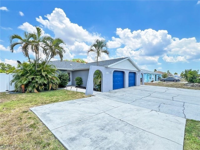 single story home featuring a garage and a front lawn