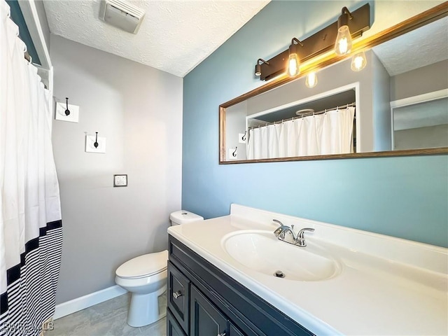 bathroom with vanity, a textured ceiling, and toilet