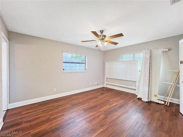 unfurnished bedroom with ceiling fan and dark hardwood / wood-style floors