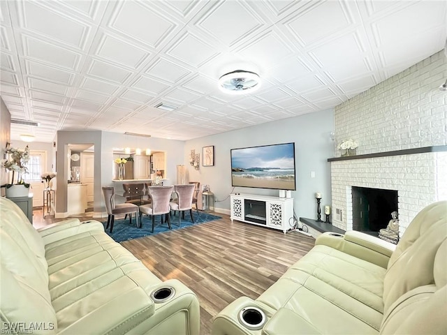 living room featuring hardwood / wood-style flooring and a brick fireplace