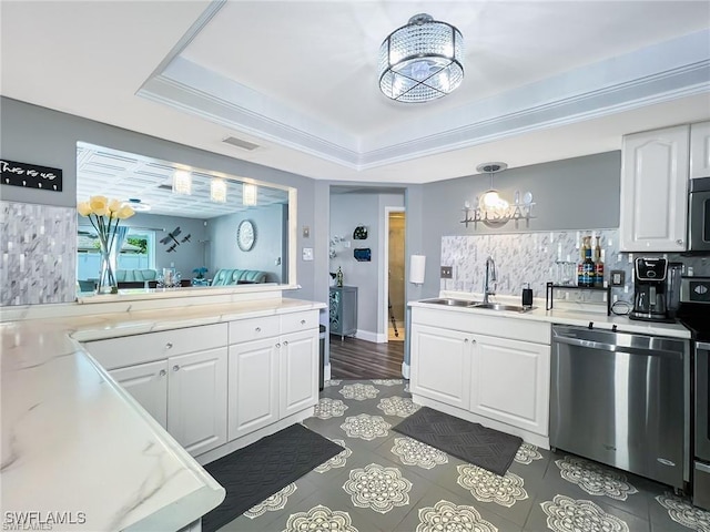 kitchen with sink, stainless steel appliances, a notable chandelier, decorative light fixtures, and white cabinets