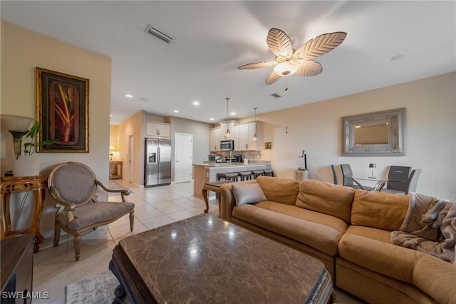 tiled living room with ceiling fan