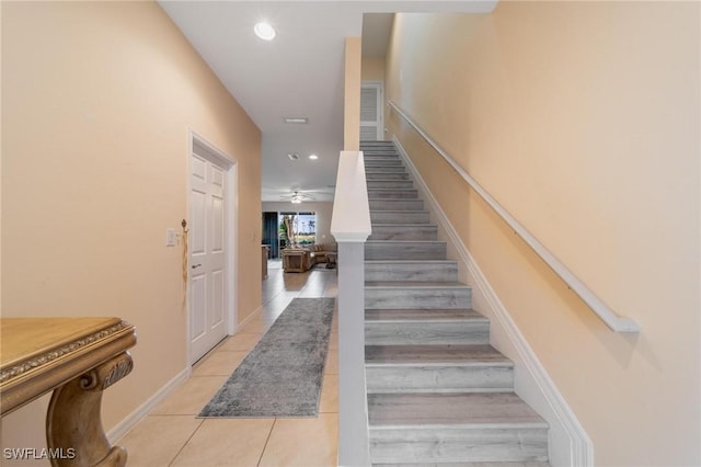 staircase with tile patterned floors and ceiling fan