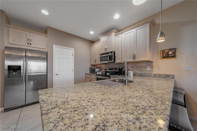 kitchen with kitchen peninsula, backsplash, stainless steel appliances, decorative light fixtures, and light tile patterned flooring