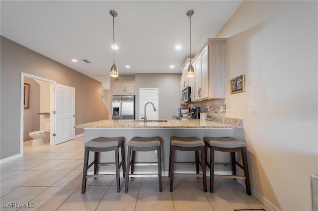 kitchen with sink, stainless steel appliances, kitchen peninsula, pendant lighting, and light tile patterned floors