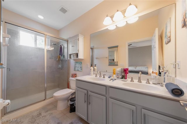 bathroom featuring tile patterned floors, vanity, toilet, and a shower with door