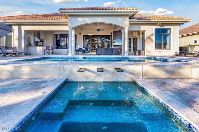 rear view of house featuring a pool with hot tub, ceiling fan, a bar, and pool water feature