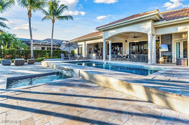 view of pool with ceiling fan, a patio, and pool water feature