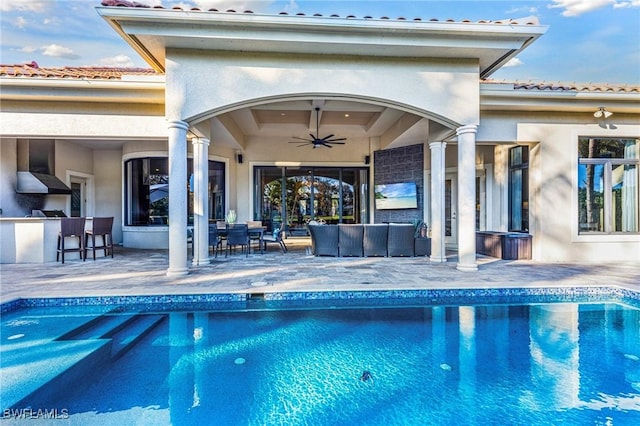 view of pool with ceiling fan, outdoor lounge area, exterior bar, and a patio