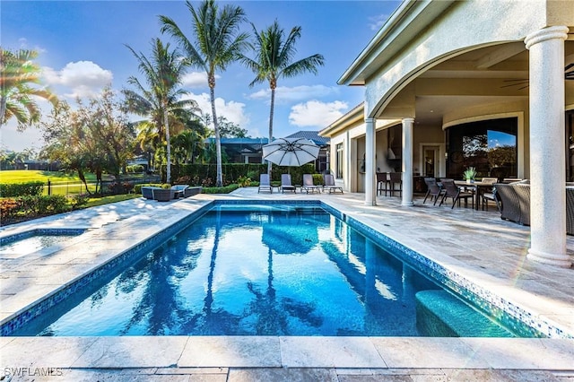 view of swimming pool featuring ceiling fan and a patio