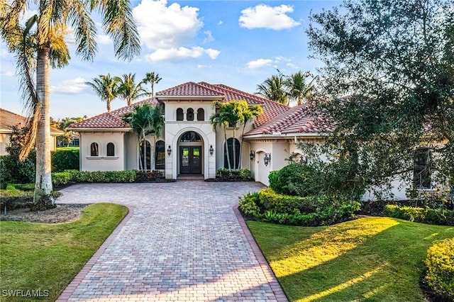 mediterranean / spanish-style home featuring a front yard and french doors