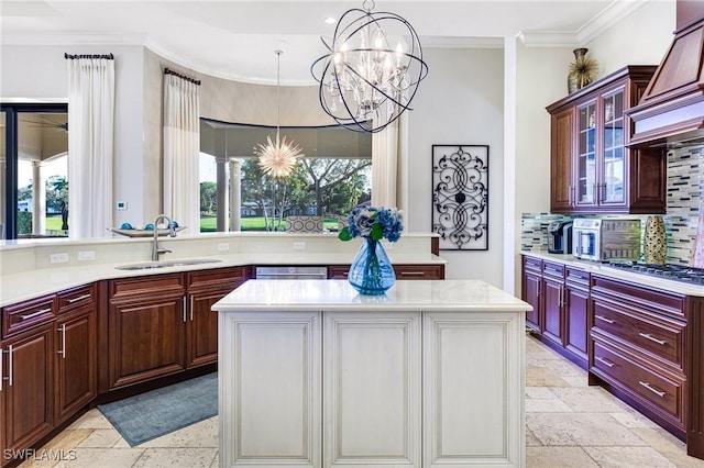 kitchen featuring sink, an inviting chandelier, a center island, and custom range hood