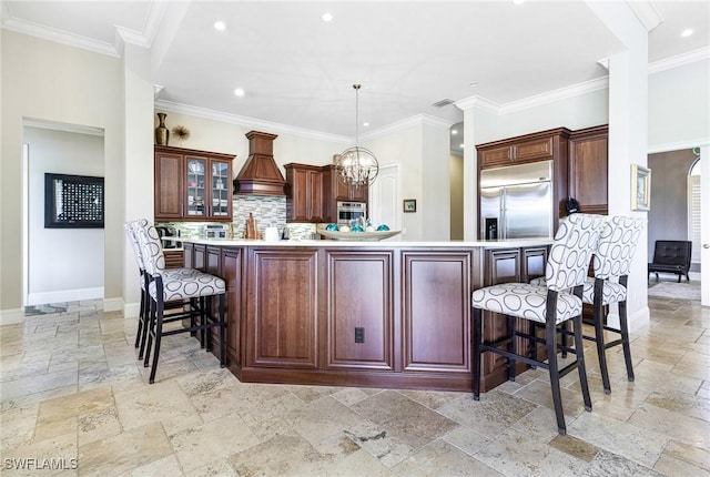 kitchen featuring crown molding, hanging light fixtures, appliances with stainless steel finishes, backsplash, and a kitchen island