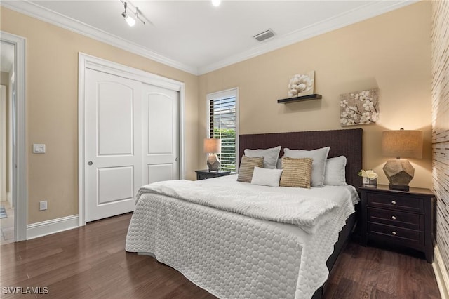 bedroom with a closet, ornamental molding, and dark wood-type flooring