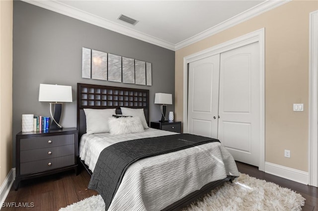 bedroom with dark hardwood / wood-style flooring, a closet, and ornamental molding