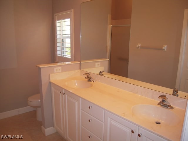 bathroom featuring tile patterned floors, vanity, toilet, and a shower with shower door