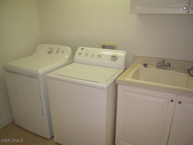 laundry room featuring sink, light tile patterned floors, cabinets, and independent washer and dryer