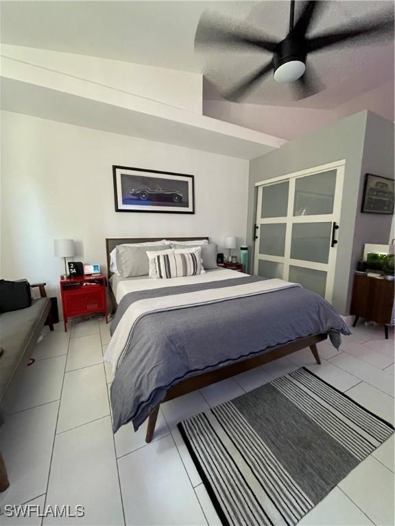 tiled bedroom with ceiling fan and vaulted ceiling