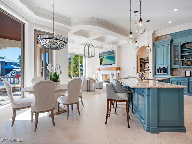 dining space featuring sink, coffered ceiling, a notable chandelier, ornamental molding, and beamed ceiling