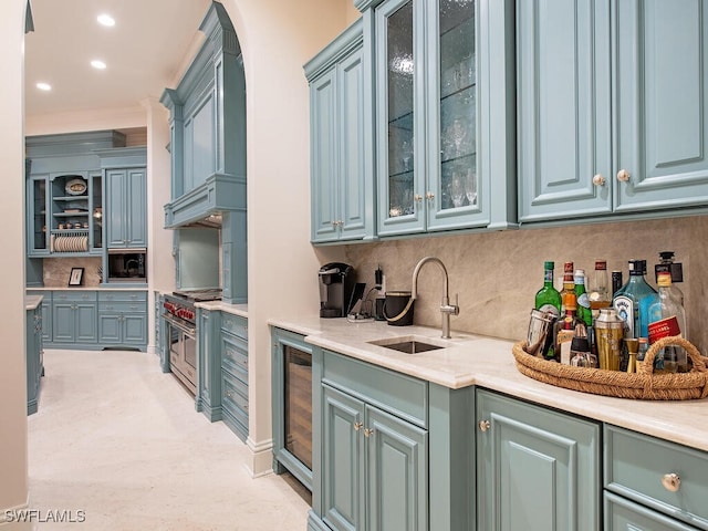 kitchen featuring beverage cooler, decorative backsplash, a sink, range with two ovens, and built in microwave