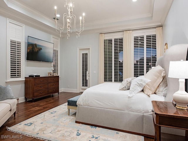 bedroom featuring ornamental molding, baseboards, a tray ceiling, and wood finished floors