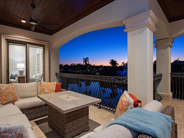 balcony at dusk featuring ceiling fan and a water view