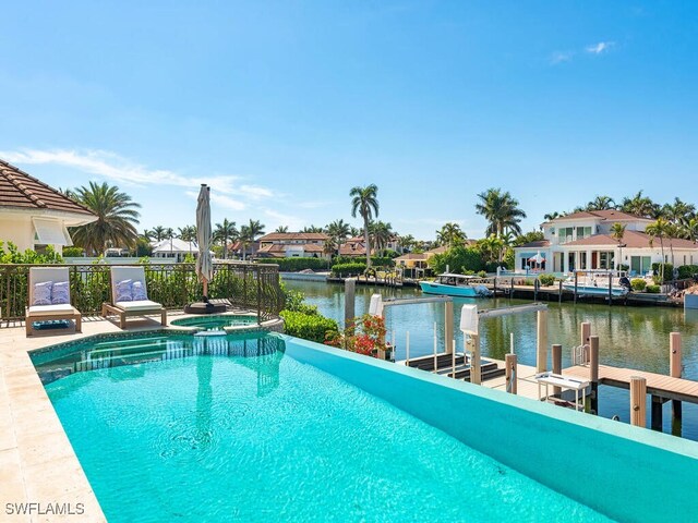 view of swimming pool with a water view, a residential view, and a boat dock