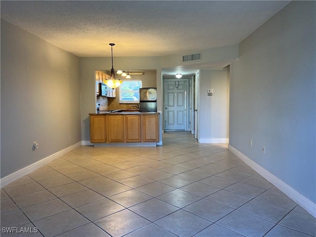 unfurnished dining area featuring light tile patterned floors, a notable chandelier, and a textured ceiling