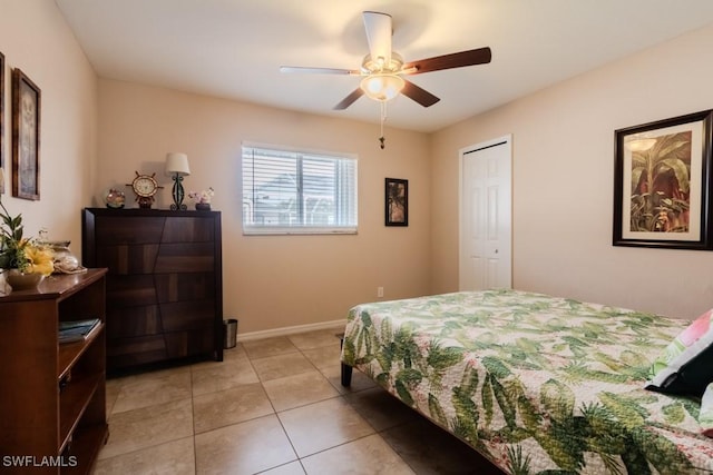 tiled bedroom featuring ceiling fan and a closet