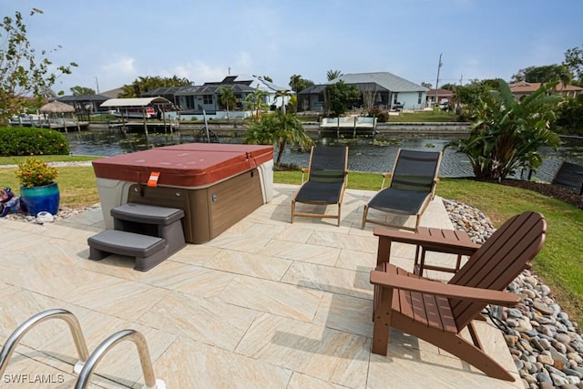 view of patio featuring a water view and a hot tub