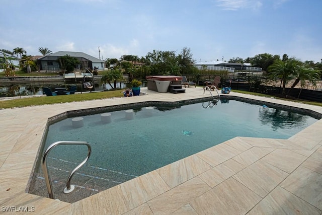 view of swimming pool with a hot tub, a water view, and a patio