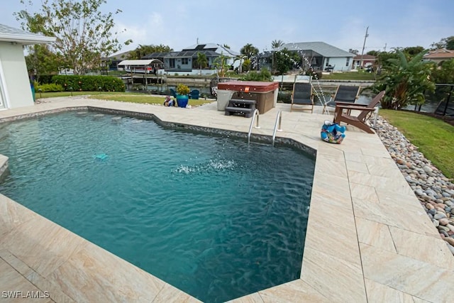 view of swimming pool with a hot tub and a patio