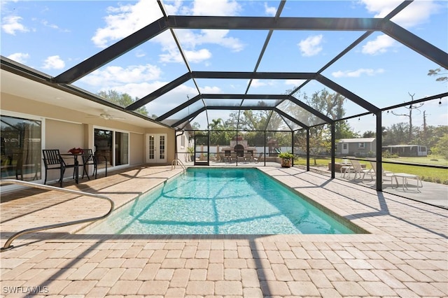 view of pool with a lanai, a fireplace, and a patio area