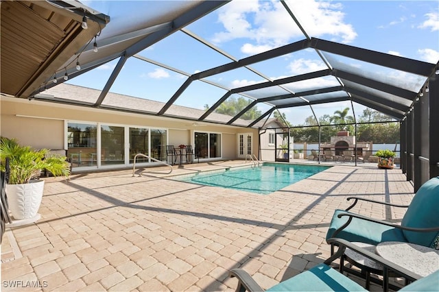 view of pool featuring a patio, glass enclosure, and a fireplace