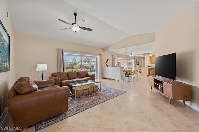 tiled living room featuring ceiling fan and vaulted ceiling