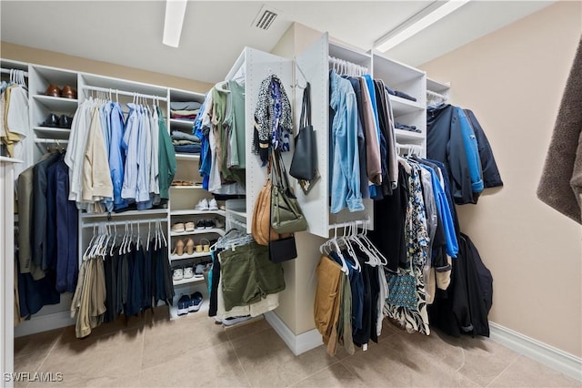 spacious closet with light tile patterned floors