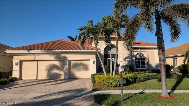 mediterranean / spanish-style home featuring a garage and a front yard